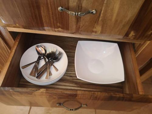a wooden shelf with a plate and utensils on it at Casa del Eucalipto in Sabana Redonda