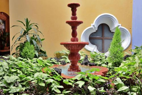 a fountain in the middle of a garden at Hotel Posada San Miguel in Antigua Guatemala