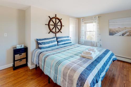 1 dormitorio con 1 cama y suelo de madera en Captain's Hidden Treasure, en South Yarmouth