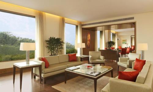 a living room filled with furniture and a large window at The Oberoi Gurgaon in Gurgaon