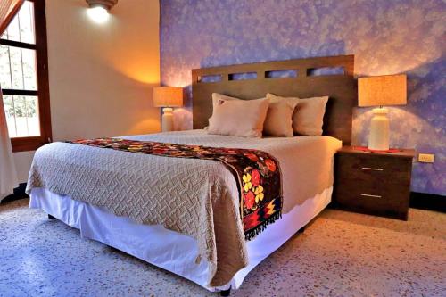 a bedroom with a large bed and a purple wall at Hotel Posada San Miguel in Antigua Guatemala