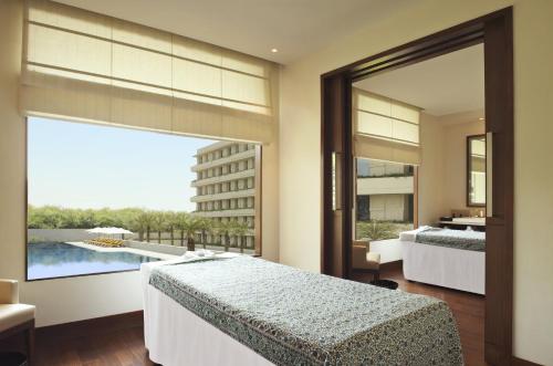 um quarto com 2 camas e uma grande janela em The Oberoi Gurgaon em Gurgaon