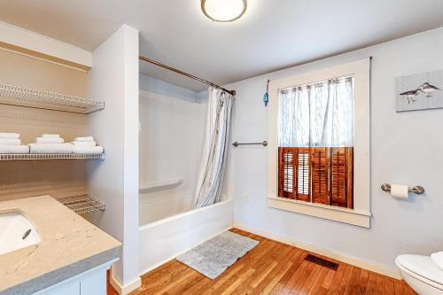 ein Bad mit einem Waschbecken und einem Fenster in der Unterkunft Cool Change in Hampton