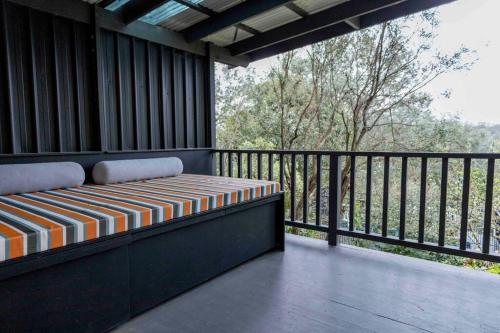 Warrandyte的住宿－Resort-style 4 bdrm home w pool, spa & billiards!，阳台设有1个带长凳的门廊,享有风景。