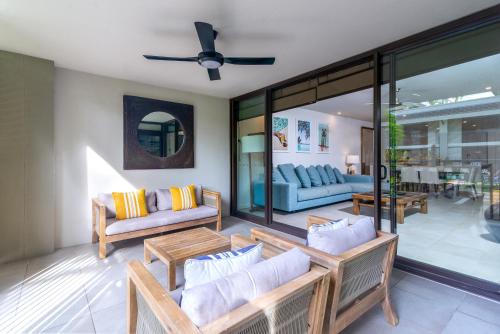 a living room with couches and a ceiling fan at Seascape Holidays at Seascape Temple in Port Douglas