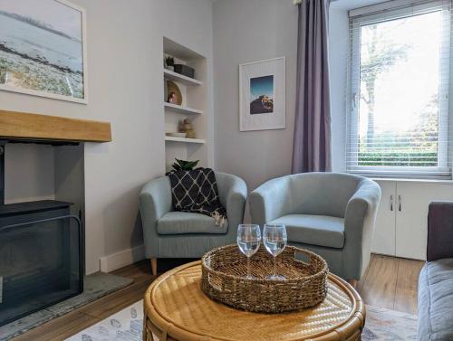 ein Wohnzimmer mit zwei Stühlen und einem Fernseher in der Unterkunft Parkview Cottage - Lovely home with cosy fireplace in Carnoustie