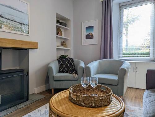 a living room with two chairs and a tv at Parkview Cottage - Lovely home overlooking park in Carnoustie