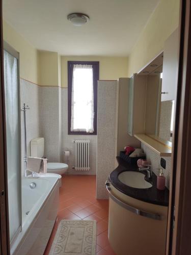 a bathroom with a sink and a tub and a toilet at Residenza tra Parma e Fiere in Baganzola