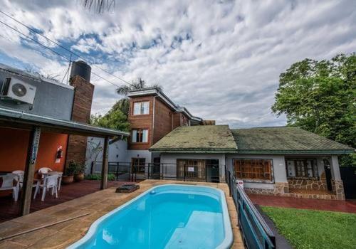 une maison avec une piscine en face d'une maison dans l'établissement Hotel Los Lapachos, à Puerto Iguazú