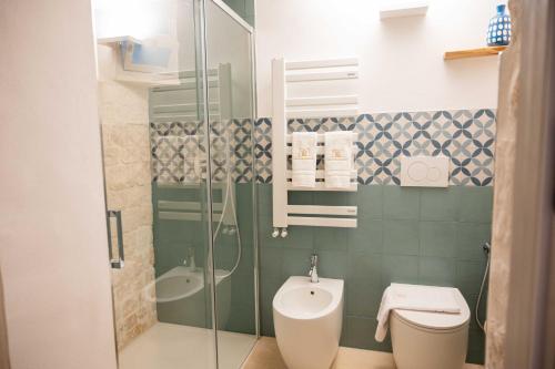 a bathroom with a shower and a toilet and a sink at Montegrappa Dimore e Suite Alberobello in Alberobello