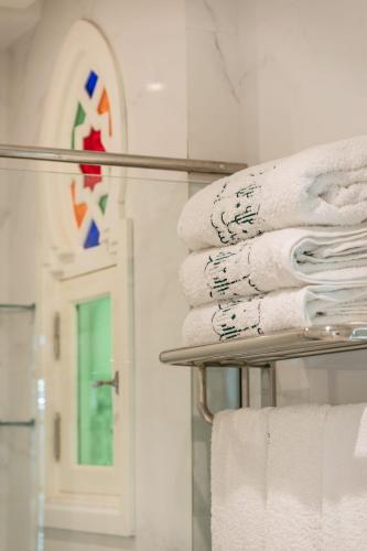 a stack of towels on a towel rack in a bathroom at HOTEL RIAD CHAMI in Marrakesh