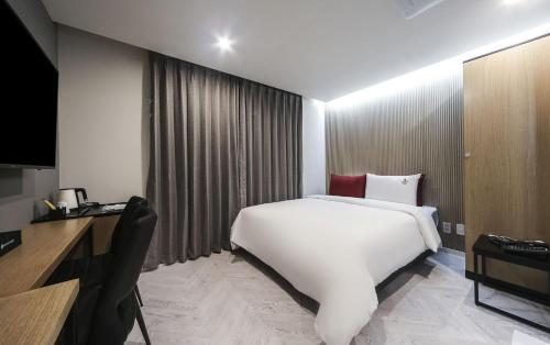 a large white bed in a hotel room at Maron Hotel Nampo in Busan
