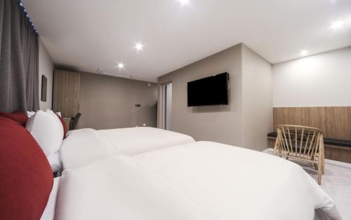 a hotel room with two beds and a flat screen tv at Maron Hotel Nampo in Busan