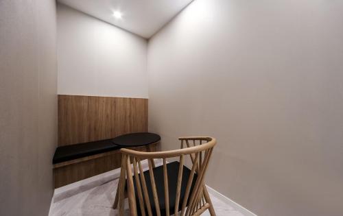 a wooden chair in a room with a table at Maron Hotel Nampo in Busan