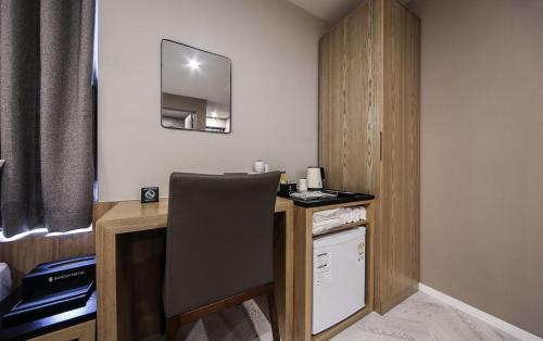 a room with a desk with a chair and a mirror at Maron Hotel Nampo in Busan
