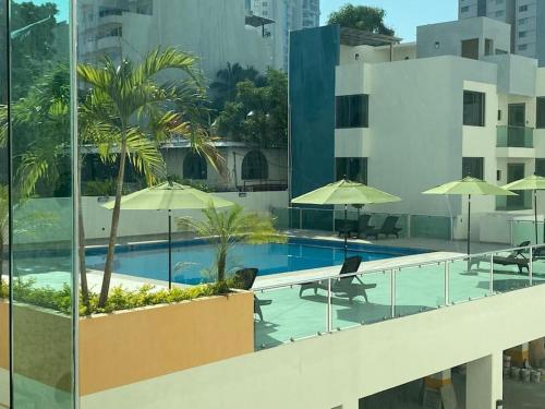 a swimming pool with chairs and umbrellas on a building at Palermo - Acapulco in Acapulco