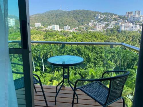 a table and two chairs on a balcony with a view at Palermo - Acapulco in Acapulco