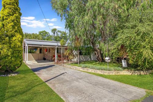 a house with a driveway in front of a yard at Abbey Beach Shack in Busselton