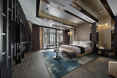 Ease Motel Taichung في تايتشونغ: غرفة نوم بسرير واريكة وطاولة
