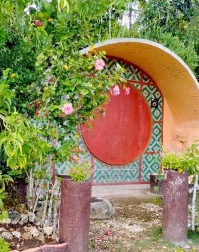 a garden with a red arch with flowers in it at Kamp Aninipot in Siquijor