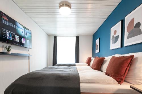 Spirit Apartments Zentral mit gratis Parkplatz في لوتزيرن: غرفة نوم بسرير كبير بجدران زرقاء