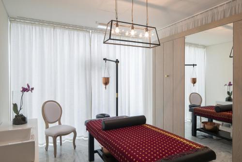 a living room with a red bed and a chair at Royal Obidos Scenic Resort in Casal da Lagoa Seca
