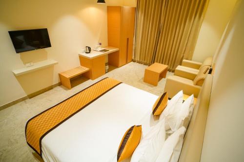 a hotel room with a bed and a television at Hotel Nakshathra- A Royal Stay in Palani