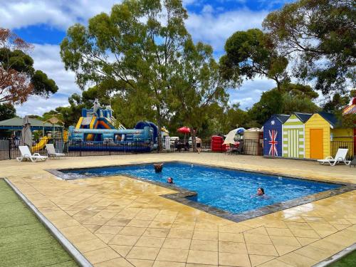 ein Pool auf einem Spielplatz mit Menschen im Wasser in der Unterkunft BIG4 Port Willunga Tourist Park in Aldinga