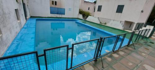 una gran piscina azul junto a un edificio en Castillo Del Lago - Carlos Paz - D24 en Villa Carlos Paz