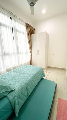 a bedroom with a bed with a green comforter at The Icon 3 Condo in IOI City Mall Putrajaya, Pool View in Putrajaya