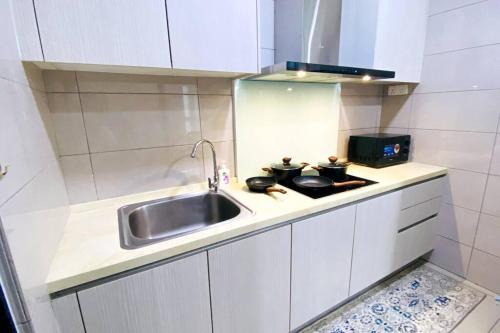 a small kitchen with a sink and a stove at The Icon 3 Condo in IOI City Mall Putrajaya, Pool View in Putrajaya