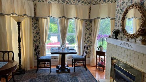 a dining room with a table and chairs and a fireplace at Bedham Hall B&B in Niagara Falls