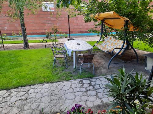 a table and chairs and an umbrella in a yard at Sissy Vendégház in Mórahalom