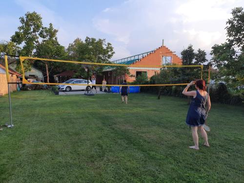 a woman playing a game of volleyball in a yard at Sissy Vendégház in Mórahalom