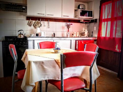 a kitchen with a table with red chairs and a stove at Departamento Urbano in San Carlos de Bariloche