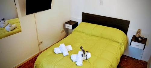 a bedroom with a yellow bed with towels on it at Departamento Urbano in San Carlos de Bariloche