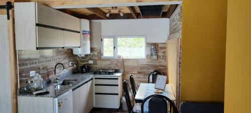 a small kitchen with a sink and a counter top at Acol in Perito Moreno