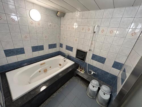a bathroom with a bath tub in a room at hotel purpleeye in Osaka