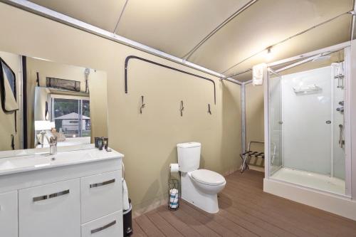 a bathroom with a toilet and a shower and a sink at Habitat Noosa in Cootharaba