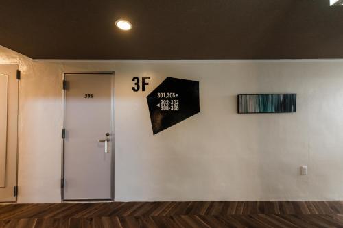 a room with a door and a sign on a wall at Hale Hotel Miyakojima in Miyako Island