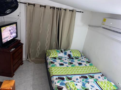 a small room with a bed and a television at Apartamento en Los Ángeles in Santa Marta