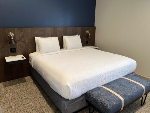 a bedroom with a large white bed and a bench at Lighthouse Oceanfront Resort in Long Beach