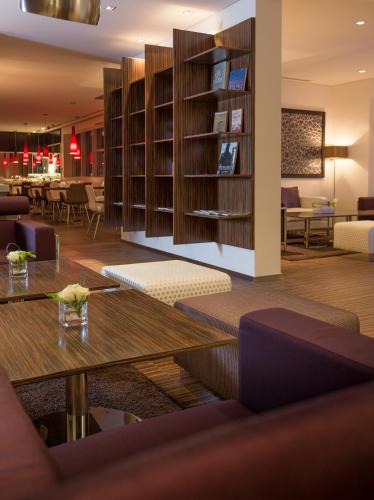 a library with wooden shelves and tables in a room at Pullman Dubai Jumeirah Lakes Towers in Dubai