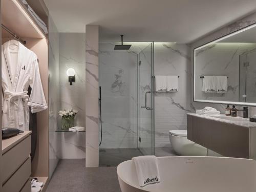 a bathroom with a shower and a toilet and a sink at The Alberti Hotel - Sukhumvit 31 in Bangkok