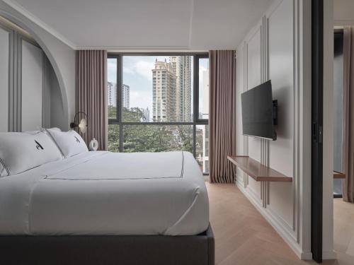 ein Schlafzimmer mit einem großen weißen Bett und einem großen Fenster in der Unterkunft The Alberti in Bangkok