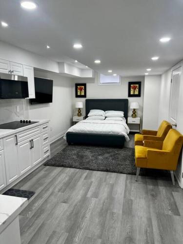 um quarto com uma cama e uma cadeira amarela em New Luxurious Studio Apartment em Brampton