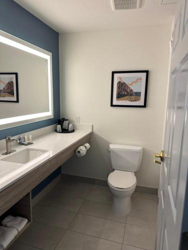 uma casa de banho com um WC, um lavatório e um espelho. em La Quinta by Wyndham Albuquerque Midtown NEWLY RENOVATED em Albuquerque