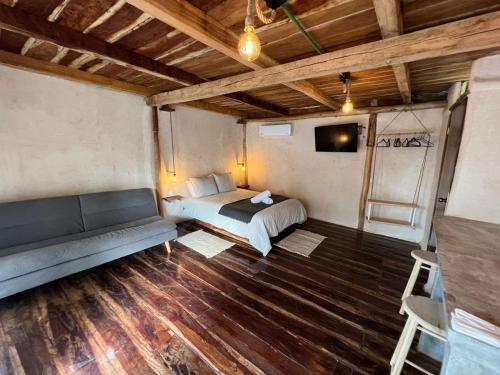 - une chambre avec un lit et un canapé dans l'établissement Xa am Natural Lodgement, à El Cuyo