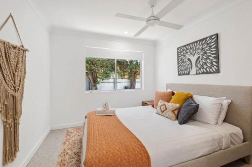 a bedroom with a bed with white walls and a window at Unit 2 11 Wentworth Avenue Nelson Bay in Nelson Bay