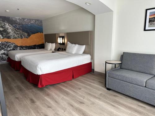 a hotel room with two beds and a couch at La Quinta Inn & Suites by Wyndham Albuquerque Midtown in Albuquerque